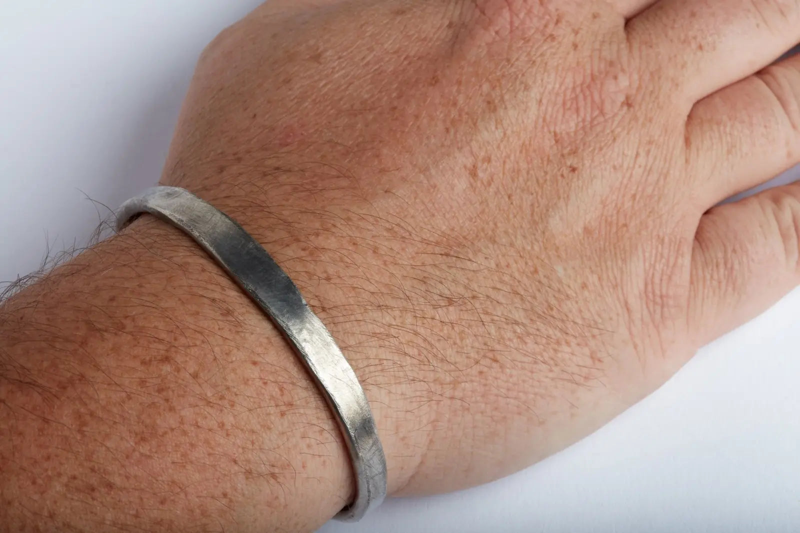 Armreif aus Sterling Silber, grob geschmiedet und gehämmert mit Totenkopf und Krone am Handgelenk